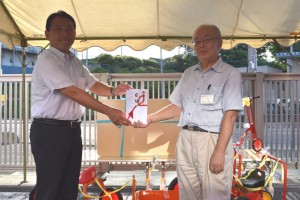 夏祭りで香川武文志木市長へ遊具を贈呈する髙野邦夫会長（右） 