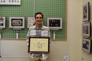 最優秀賞の作品展示（右）で笑顔を見せる佐藤さん